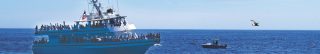 image of whale breaching with large ship in the background